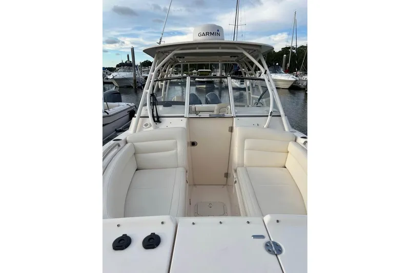 Slide: The Image of 2020 Grady-White Freedom 285 boat with white seating, docked in a marina. - 8
