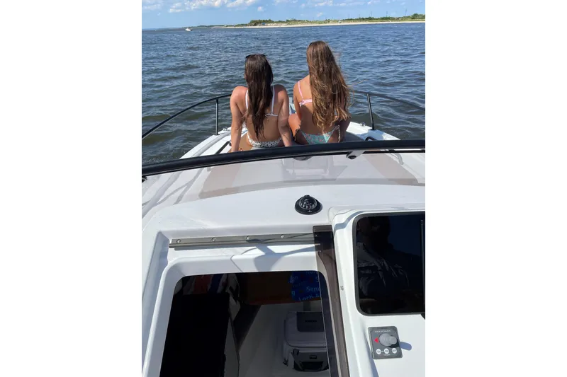 Slide: The Image of Two people relaxing on a 2022 Beneteau Flyer 8 SUNdeck boat, enjoying the water view. - 17