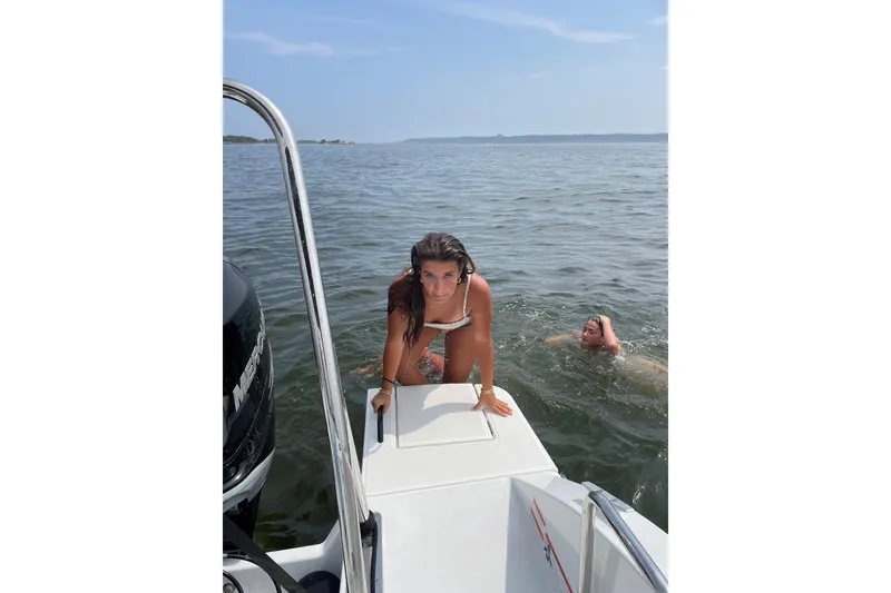 Slide: The Image of Two people enjoying a swim near a 2022 Beneteau Flyer 8 SUNdeck boat. - 19