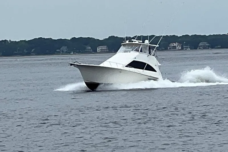 Slide: The Image of 2002 Ocean Yachts 56 Super Sport cruising on open water, creating a dynamic wake. - 1