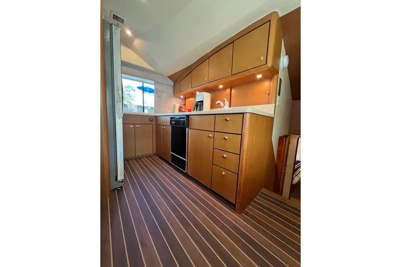 Slide: The Image of Luxurious kitchen interior of 2002 Ocean Yachts 56 Super Sport with wood cabinetry and modern appliances. - 13