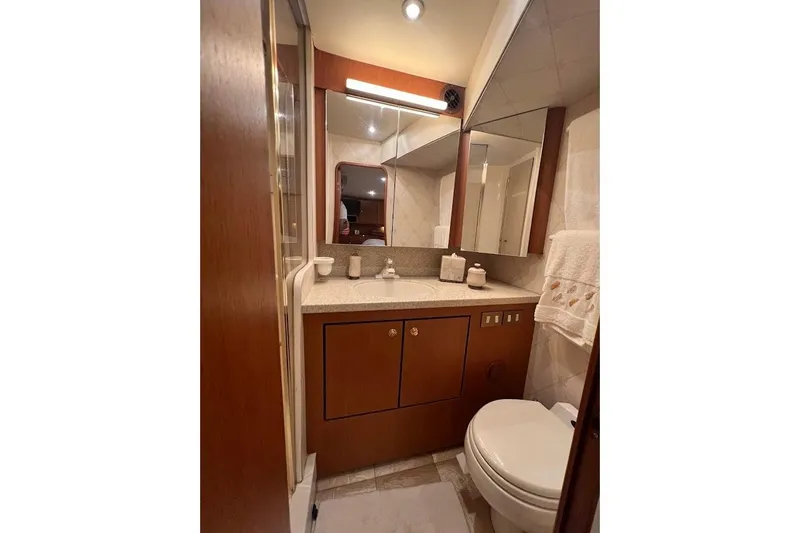 Slide: The Image of Luxurious bathroom in 2002 Ocean Yachts 56 Super Sport, featuring elegant wood cabinetry and modern fixtures. - 19