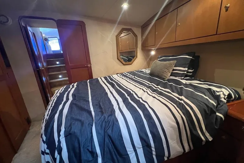 Slide: The Image of Luxurious bedroom in 2002 Ocean Yachts 56 Super Sport with striped bedding and wooden cabinetry. - 20