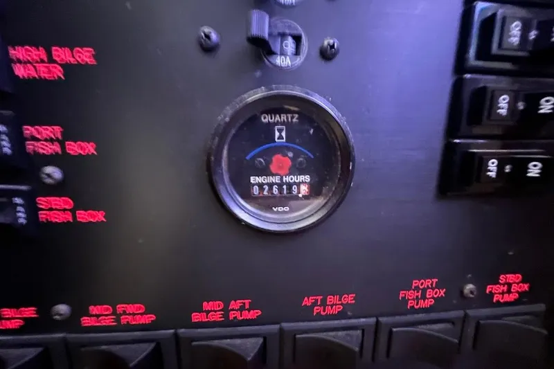 Slide: The Image of Control panel of a 2002 Ocean Yachts 56 Super Sport, showing engine hours and switches. - 33