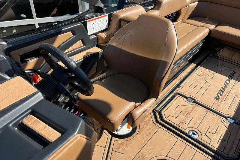 Slide: The Image of 2022 Moomba Makai boat interior with tan seating and sleek dashboard design. - 13