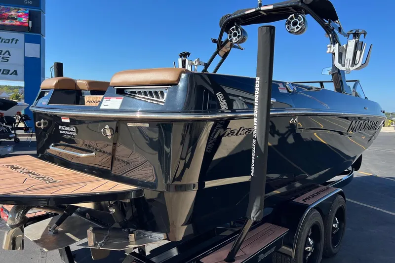Slide: The Image of 2022 Moomba Makai boat on trailer, featuring sleek black design and modern wakeboard tower. - 4