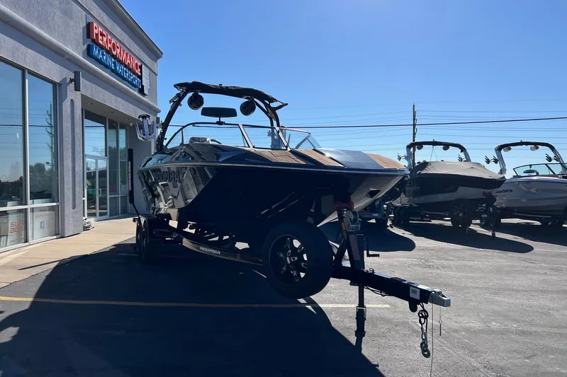 Slide: The Image of 2022 Moomba Makai boat on trailer outside Performance Marine Watersports dealership. - 6