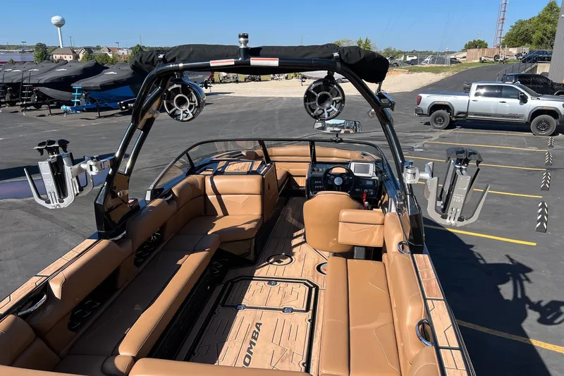 Slide: The Image of 2022 Moomba Makai boat with tan interior, parked in a lot with a truck nearby. - 8