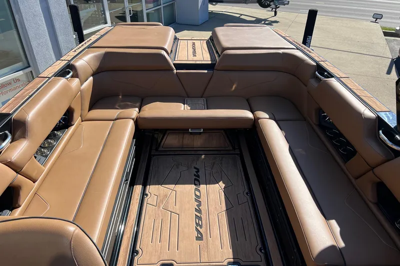 Slide: The Image of 2022 Moomba Makai boat interior with tan leather seating and wood flooring. - 9