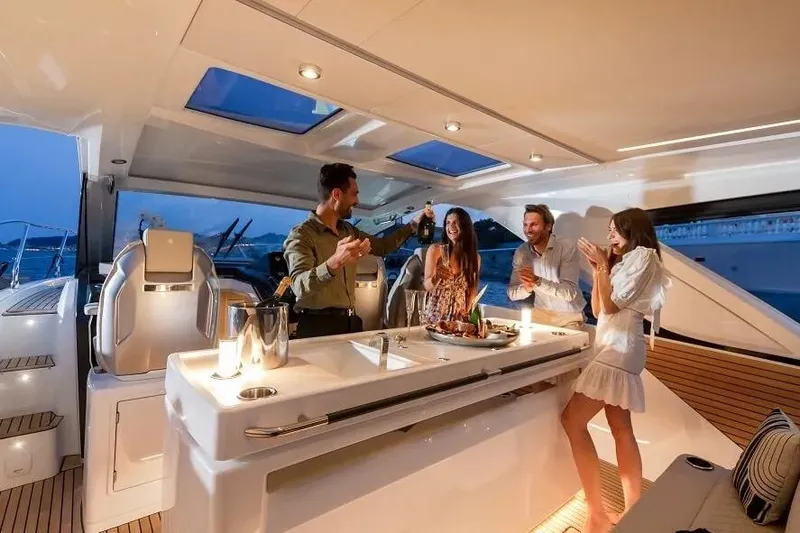 Slide: The Image of People enjoying a celebration on a 2026 Jeanneau DB 43 yacht at sunset. - 1