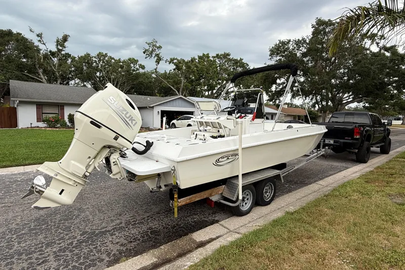 Slide: The Image of Spectre 22CC 2002 boat with Suzuki outboard motor on trailer, parked on suburban street. - 4