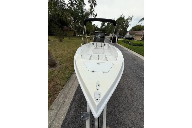 Slide: The Image of 2002 Spectre 22CC boat on trailer, parked on suburban street with trees. - 5