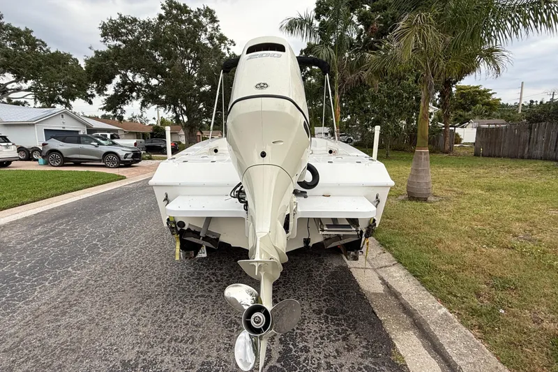 Slide: The Image of 2002 Spectre 22CC boat with outboard motor parked on residential street. - 6