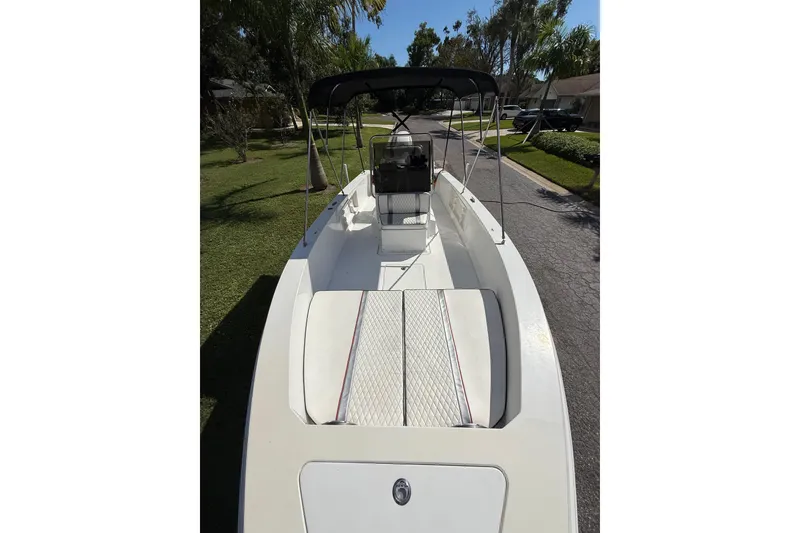 Slide: The Image of 2002 Spectre 22CC boat with canopy, parked on a residential street. - 7