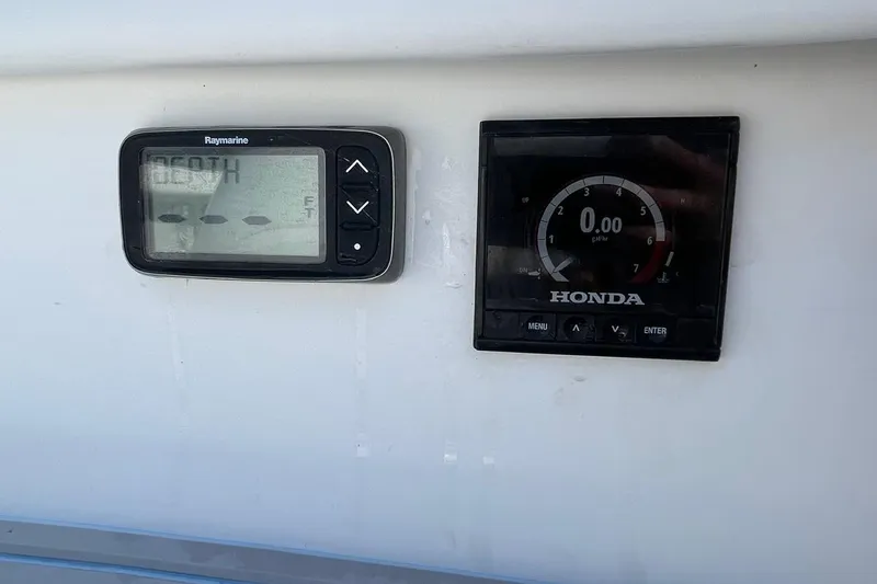 Slide: The Image of 2006 Chaos 16 Bonefish boat dashboard with Raymarine and Honda displays. - 17