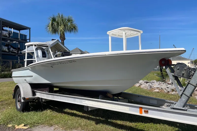 Slide: The Image of 2006 Chaos 16 Bonefish boat on trailer, parked outdoors under clear blue sky. - 2