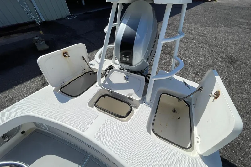 Slide: The Image of 2006 Chaos 16 Bonefish boat with open storage compartments and Honda outboard motor. - 20