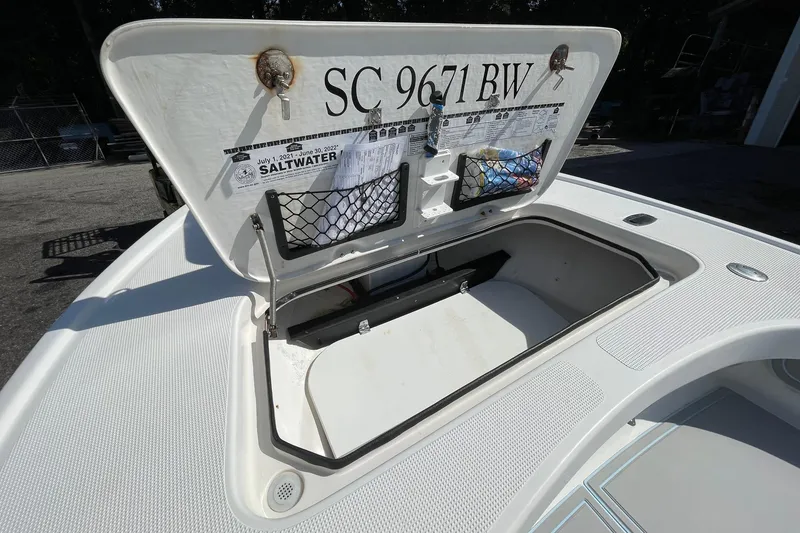 Slide: The Image of Open storage compartment on a 2006 Chaos 16 Bonefish boat, featuring registration details. - 27