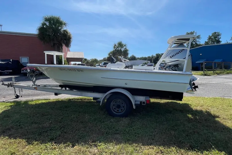 Slide: The Image of 2006 Chaos 16 Bonefish boat on trailer with Honda outboard motor, parked outdoors. - 5