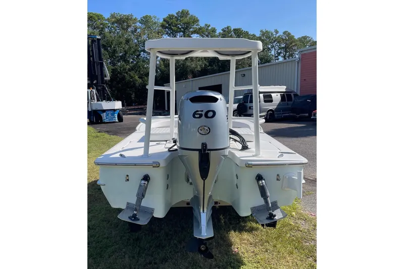 Slide: The Image of 2006 Chaos 16 Bonefish boat with 60 HP outboard motor, parked outdoors. - 6