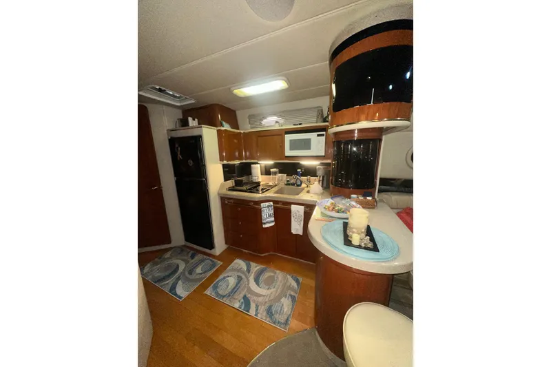 Slide: The Image of Interior of 1998 Sea Ray 500 Sundancer yacht kitchen with modern amenities and wooden cabinetry. - 10