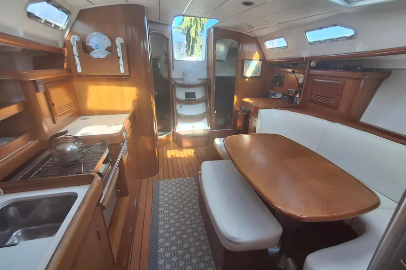 Slide: The Image of Interior of 2006 Beneteau Oceanis 393 yacht with wooden furnishings and dining area. - 12