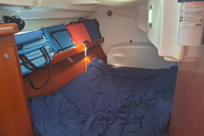 Slide: The Image of Cozy cabin interior of 2006 Beneteau Oceanis 393 sailboat with blue bedding and storage. - 13