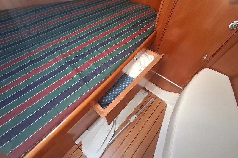 Slide: The Image of Beneteau Oceanis 393 cabin interior with striped bedding and open storage drawer, 2006 model. - 17