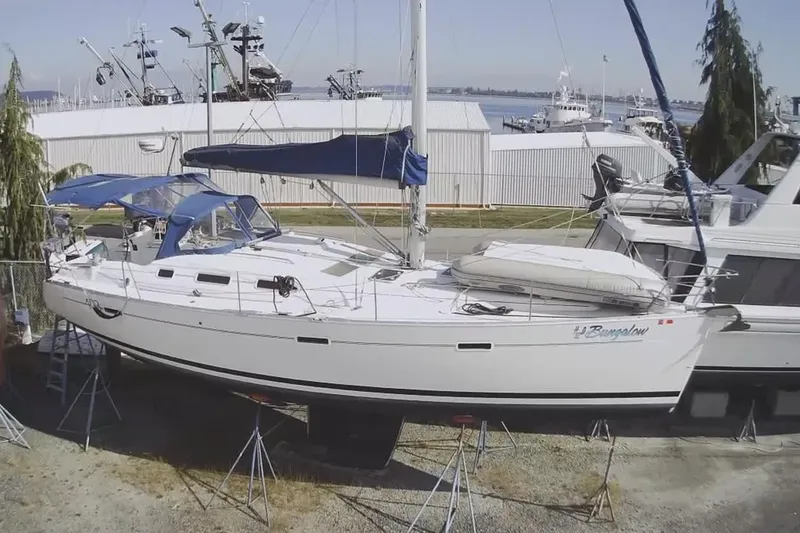 Slide: The Image of 2006 Beneteau Oceanis 393 sailboat on stands, marina background, blue canopy. - 3