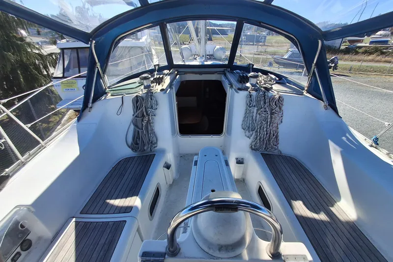 Slide: The Image of 2006 Beneteau Oceanis 393 sailboat cockpit with ropes and seating, under blue canopy. - 5