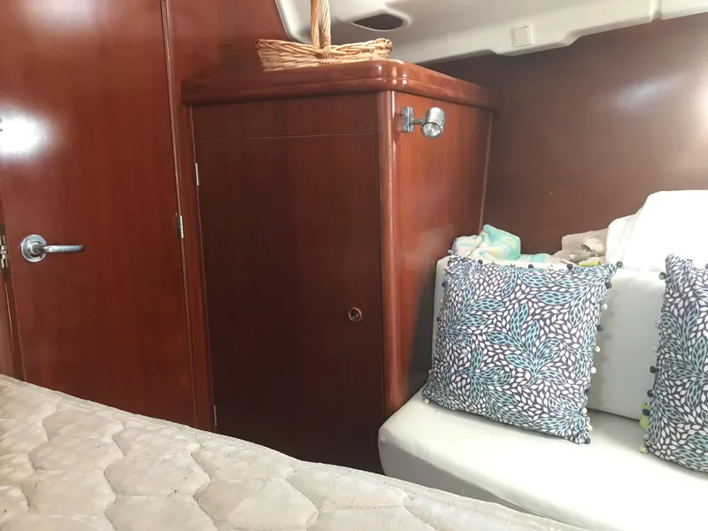 Slide: The Image of Interior of 2003 Beneteau 411 yacht with wooden cabinetry and patterned cushions. - 11