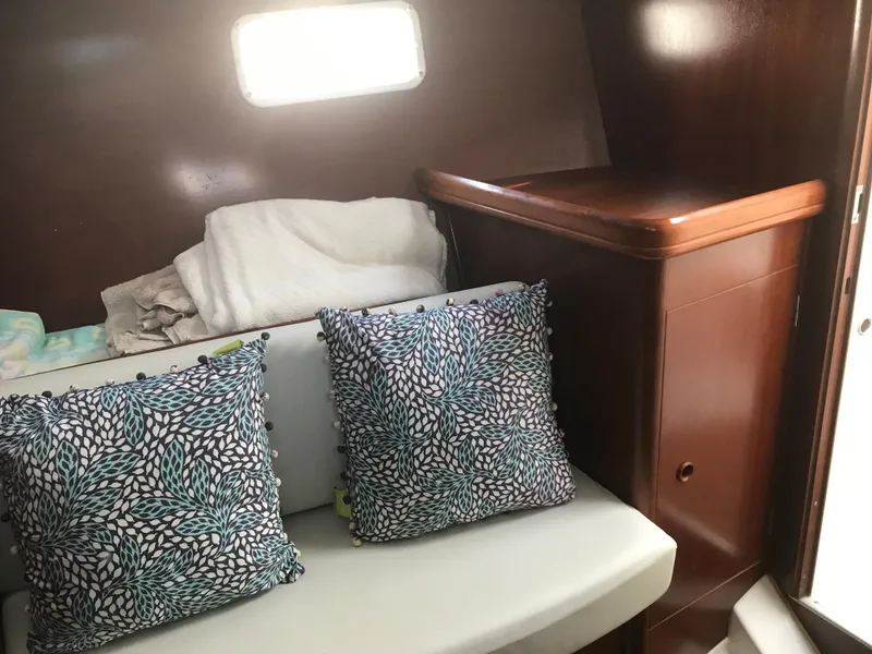 Slide: The Image of Interior of 2003 Beneteau 411 sailboat with cushions and wooden cabinetry. - 12