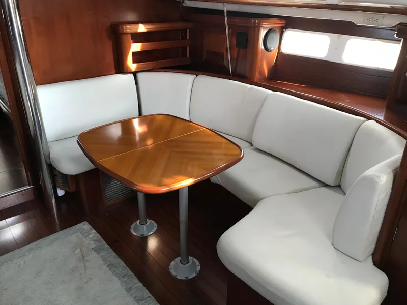 Slide: The Image of Interior of 2003 Beneteau 411 sailboat with white seating and wooden table. - 5