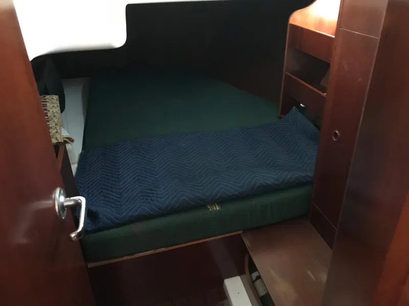 Slide: The Image of Cozy cabin interior of 2003 Beneteau 411 sailboat with wooden finish and green bedding. - 8