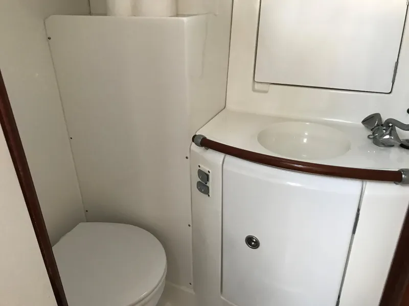 Slide: The Image of Compact bathroom in a 2003 Beneteau 411 yacht, featuring a toilet and sink. - 9