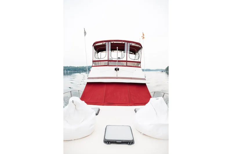 Slide: The Image of 1982 Trojan F-36 Convertible boat with red canopy on calm water. - 2
