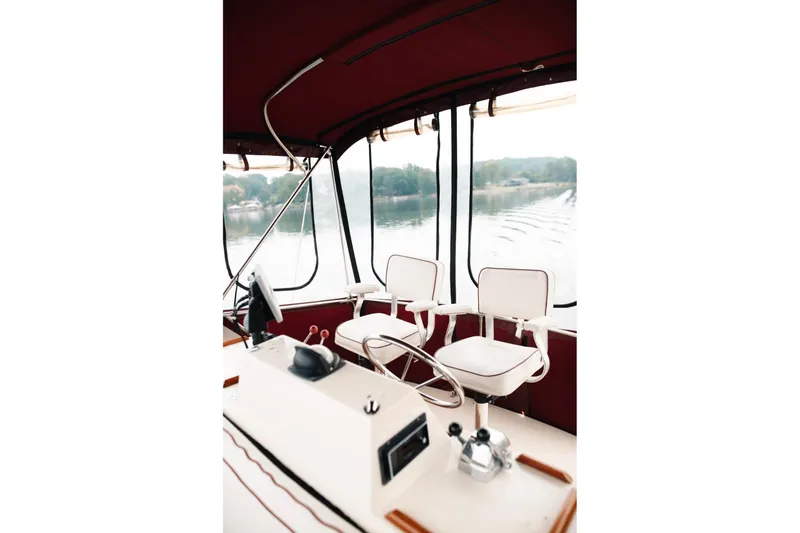 Slide: The Image of Interior of 1982 Trojan F-36 Convertible boat with helm and white seating. - 26