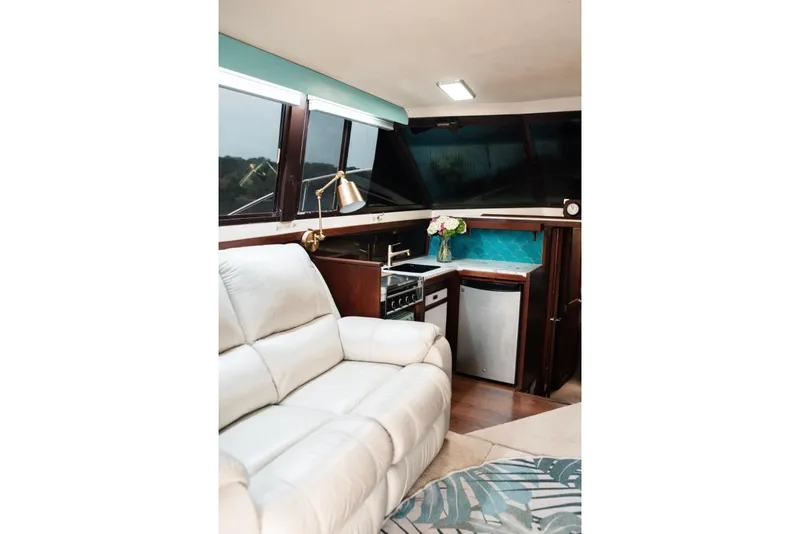 Slide: The Image of Interior of 1982 Trojan F-36 Convertible yacht with cozy seating and compact kitchen area. - 9