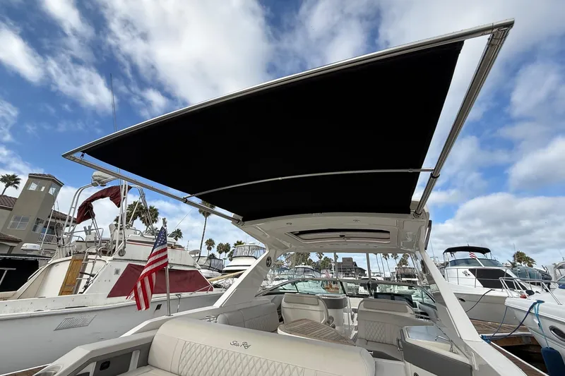 Slide: The Image of 2023 Sea Ray SLX 310 Outboard boat with canopy, docked in marina. - 14