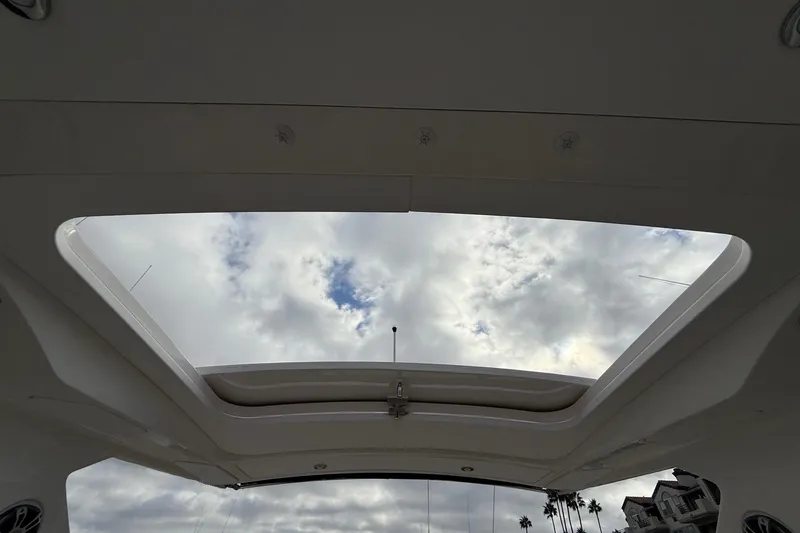 Slide: The Image of 2023 Sea Ray SLX 310 Outboard sunroof view with cloudy sky background. - 16