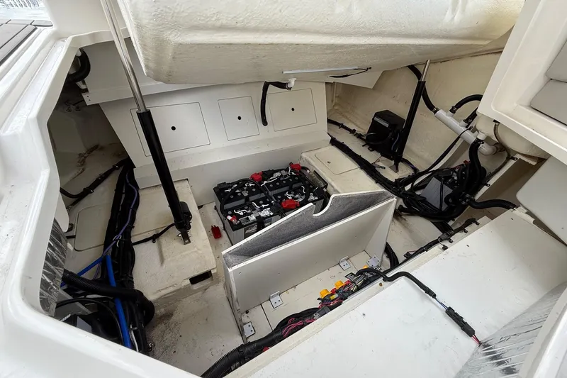 Slide: The Image of 2023 Sea Ray SLX 310 Outboard engine compartment with visible wiring and battery setup. - 25