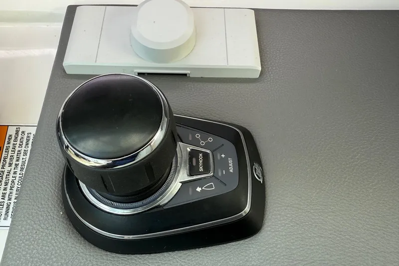 Slide: The Image of Control panel of 2023 Sea Ray SLX 310 Outboard boat, featuring joystick and adjustment buttons. - 38