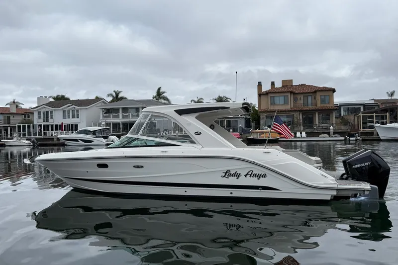 Slide: The Image of 2023 Sea Ray SLX 310 Outboard boat docked in a residential marina. - 5