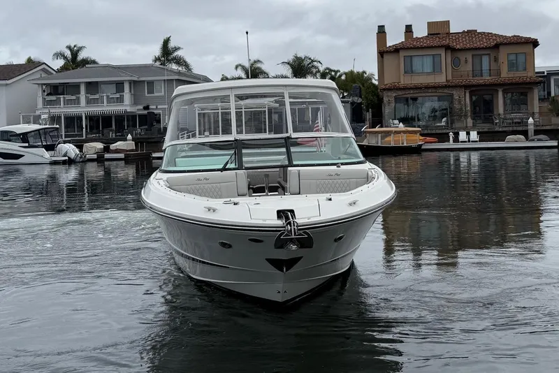 Slide: The Image of 2023 Sea Ray SLX 310 Outboard boat docked in a residential waterfront area. - 7