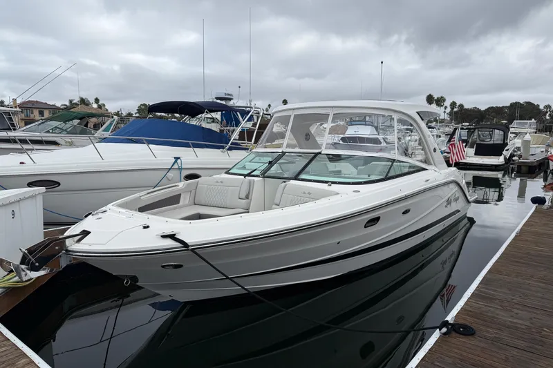 Slide: The Image of 2023 Sea Ray SLX 310 Outboard boat docked at marina under cloudy sky. - 8