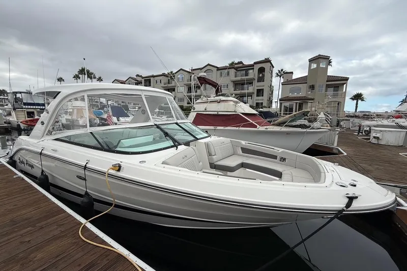 Slide: The Image of 2023 Sea Ray SLX 310 Outboard docked at marina with luxury waterfront homes. - 9