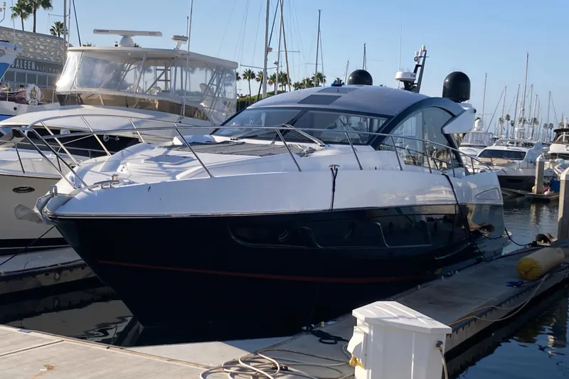 The Image of 2019 Sunseeker Predator 57 yacht on calm water, coastal cityscape in background. - 1