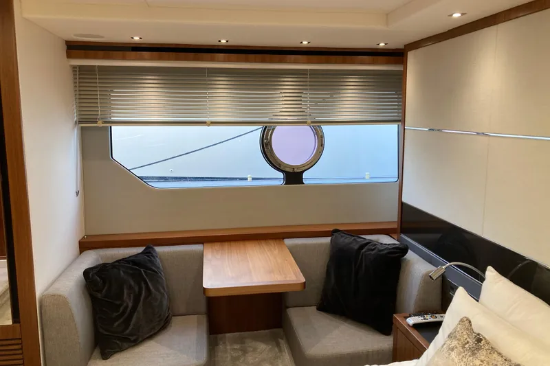 Slide: The Image of 2019 Sunseeker Predator 57 yacht on calm waters with coastal backdrop. - 11