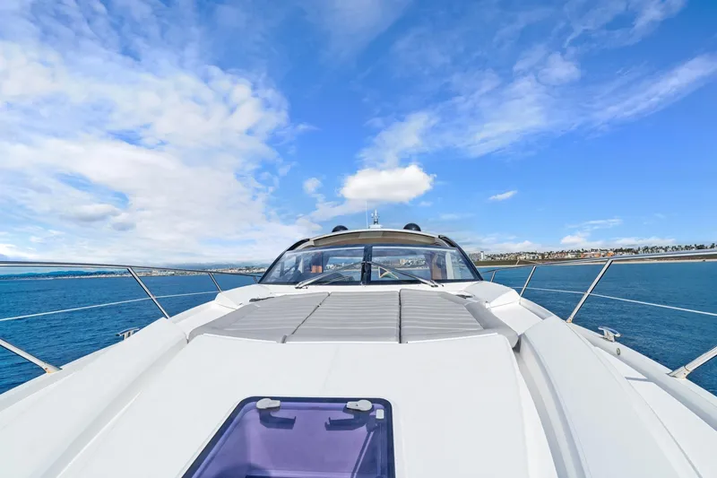 Slide: The Image of 2019 Sunseeker Predator 57 yacht docked in a busy marina under a clear blue sky. - 24