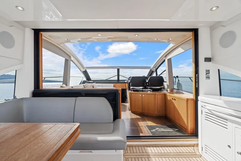 Slide: The Image of 2019 Sunseeker Predator 57 yacht with flag, ocean view, and coastal background. - 28